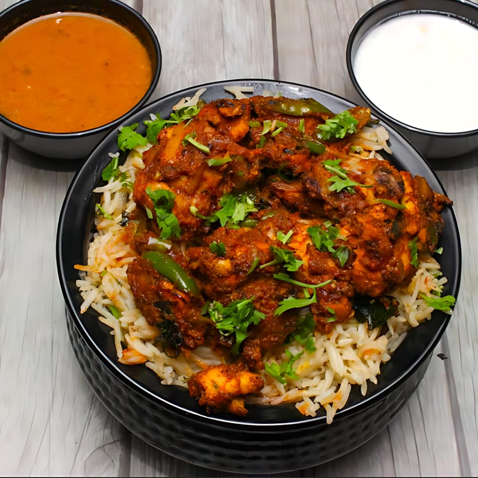Chicken Biryani with rice, green peppers, cilantro, and two side bowls of sauce.